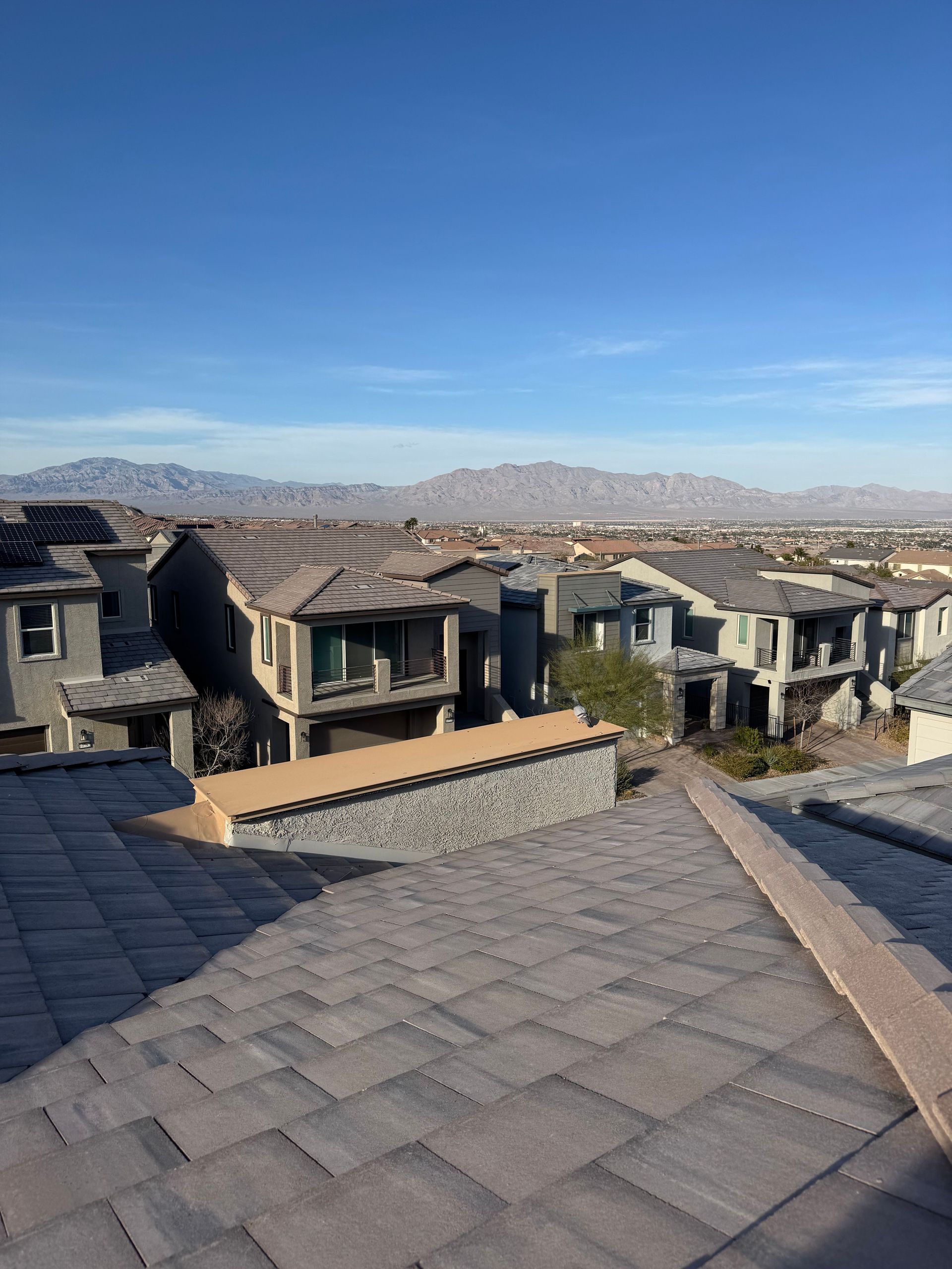 Suburban homes with tiled roofs under a clear blue sky in Las Vegas.