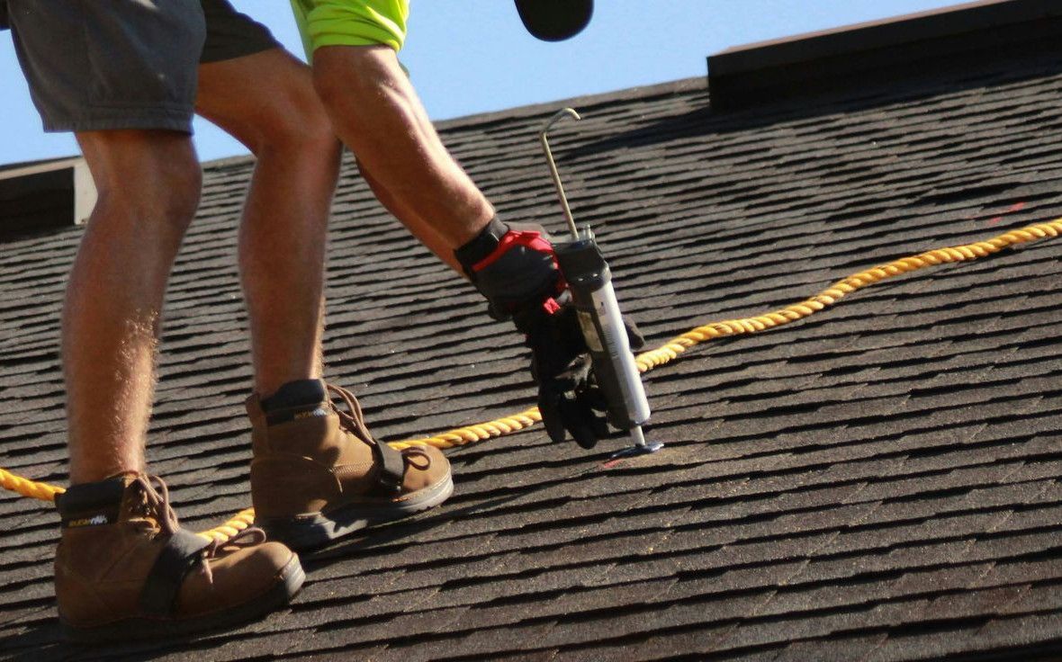 a man working on a roof with a power drill