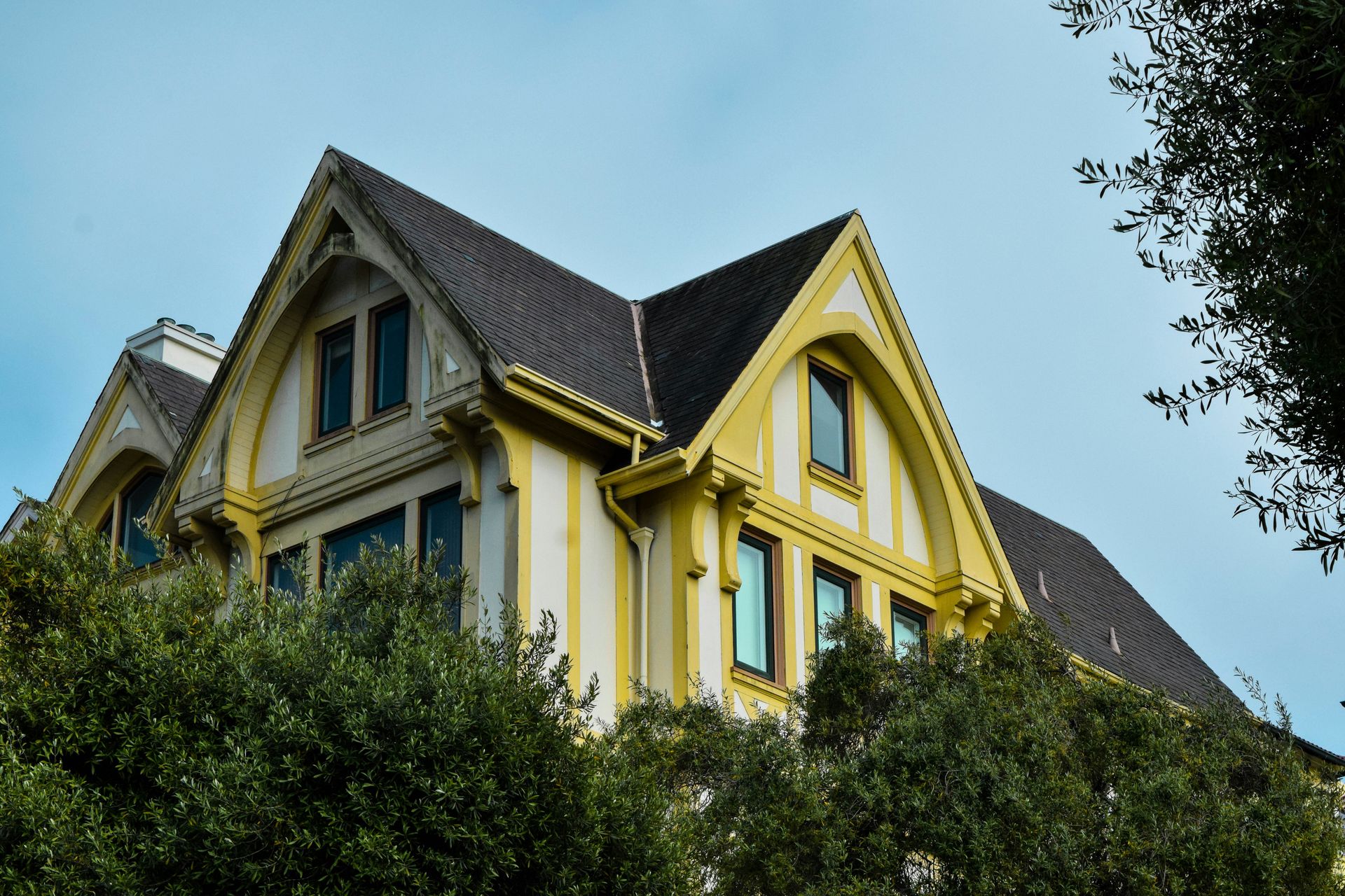 a large yellow house with a black roof