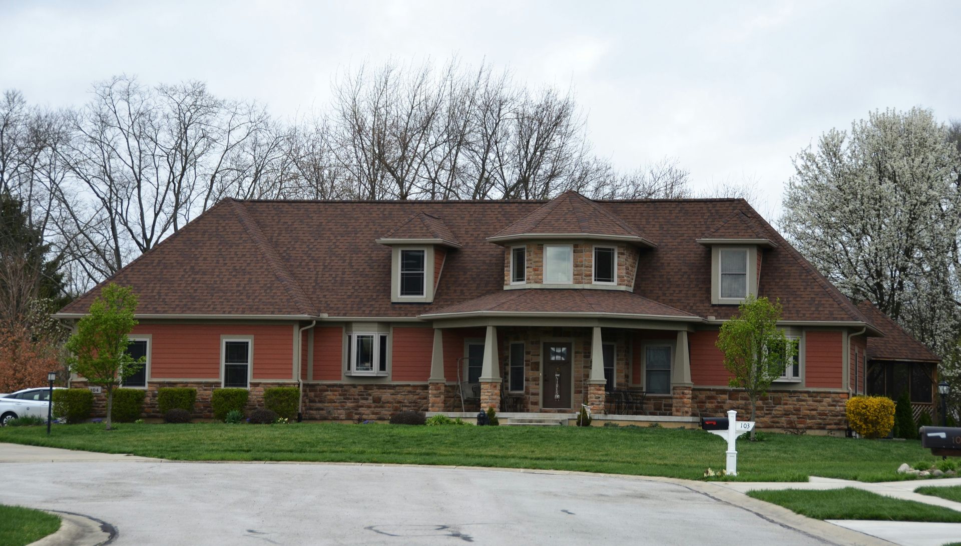 a red brick house with a car parked in front of it
